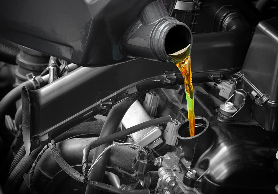 Pouring motor oil into car engine